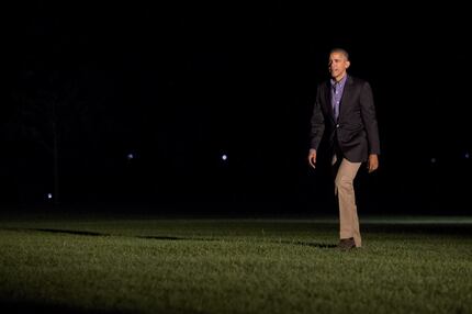 President Barack Obama returns from a shortened visit to Spain, as he walks across the South...