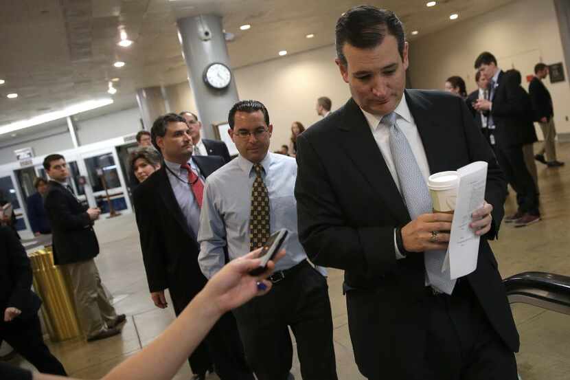  Presidential candidate Sen. Ted Cruz is trailed by reporters as he walks to the Senate...