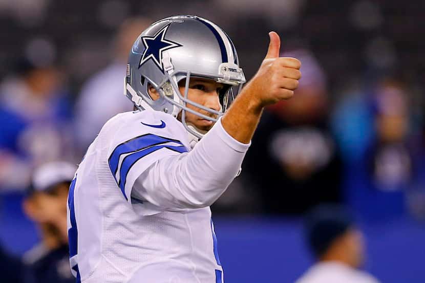 Dallas Cowboys quarterback Tony Romo (9) gives a thumbs up to his teammates before their...
