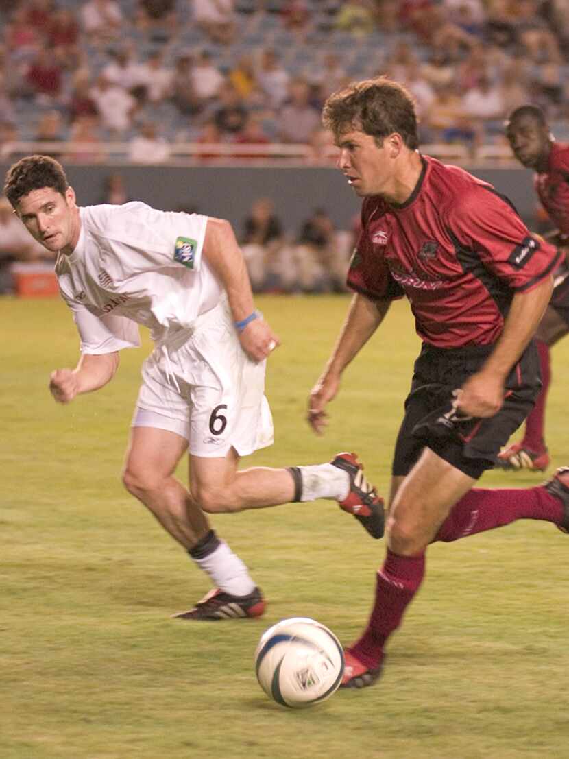 Eric Quill playing for the Dallas Burn in 2004 attempting to dribble past Jay Heaps of the...