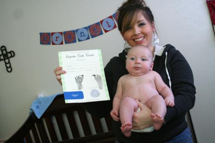 
Victoria Greene and her son Brantley Smith display a keepsake chart from his birth at...