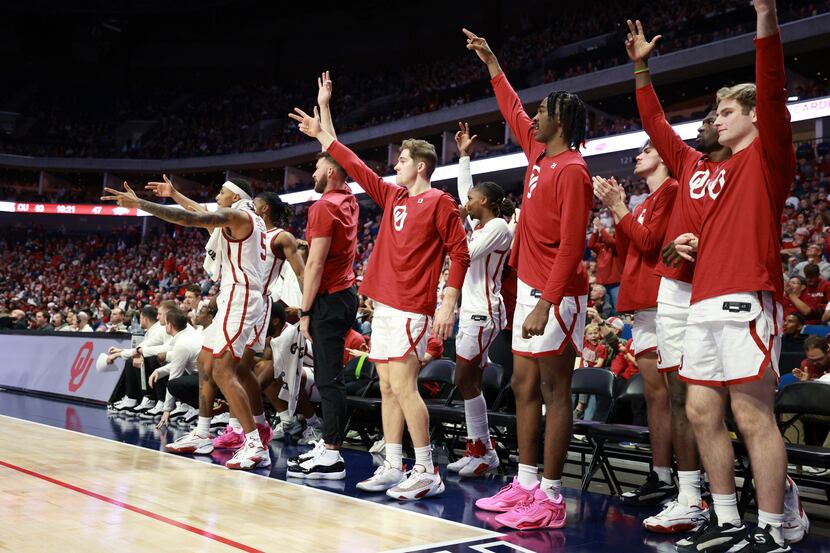 Oklahoma players cheer after a 3-point basket during the second half of an NCAA college...