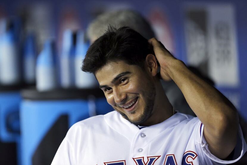 Texas Rangers starting pitcher Martin Perez (33) laughs in the dugout between innings...