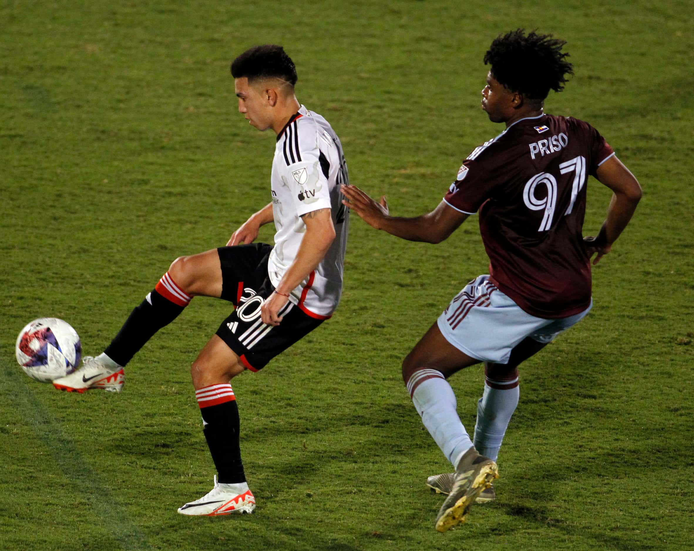 FC Dallas midfielder Alan Velasco (20), left, controls the ball against the defense of...
