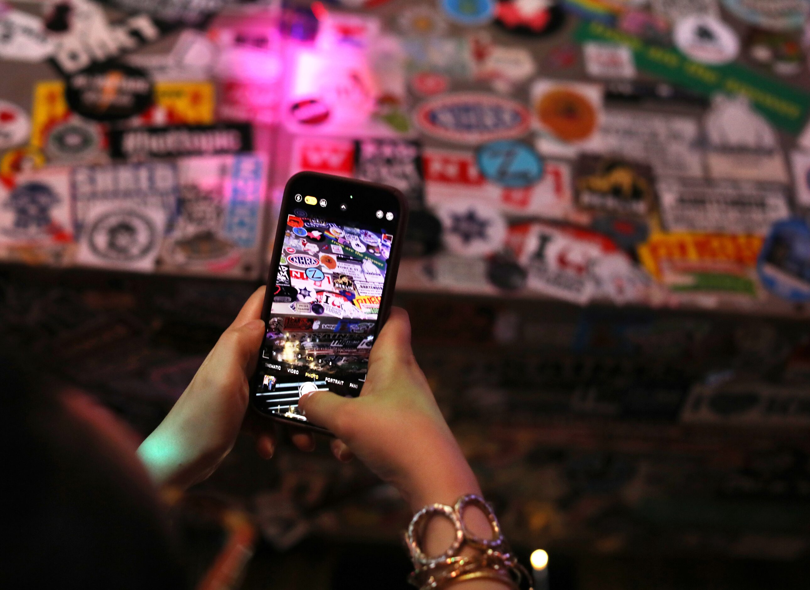 Dee Scurlock takes photos of the stickers at the Grapevine Bar in Dallas, TX, on Aug 23,...