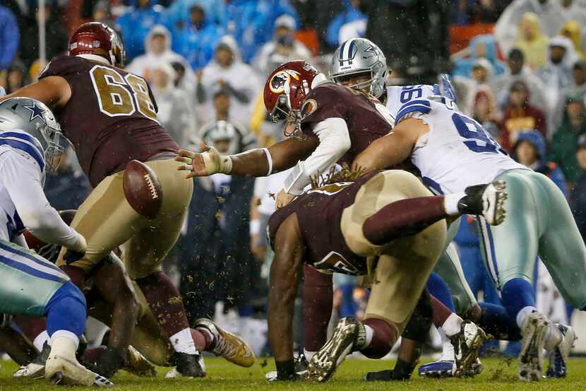 Washington Redskins quarterback Kirk Cousins (8) fumbles the ball as he's tackled by Dallas...