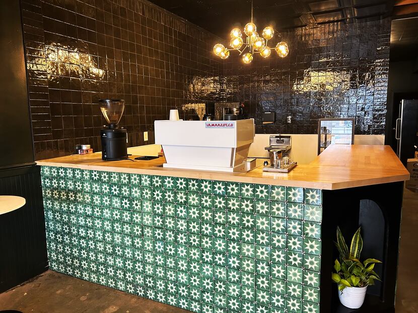 Counter in a coffee shop adorned with green and white painted tile.