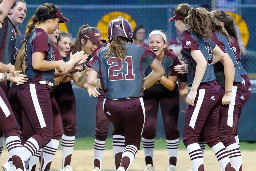 Plano's Lindsay Edwards (21) is congratulated at home plate after hitting a home run in a...