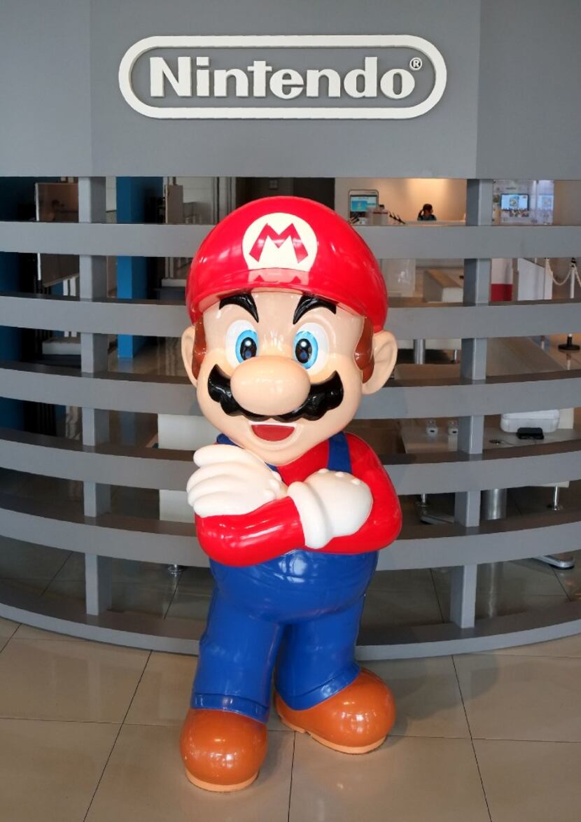 The logo of Japanese gaming giant Nintendo and its game character Super Mario on display at...