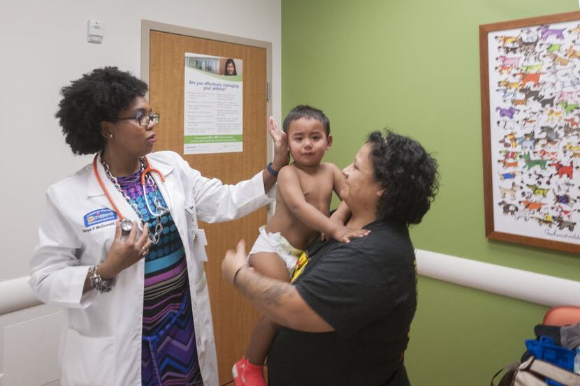 Dr. Tonya McDonald, left, a pediatrician at My Children's Clinic in South Dallas, performs a...