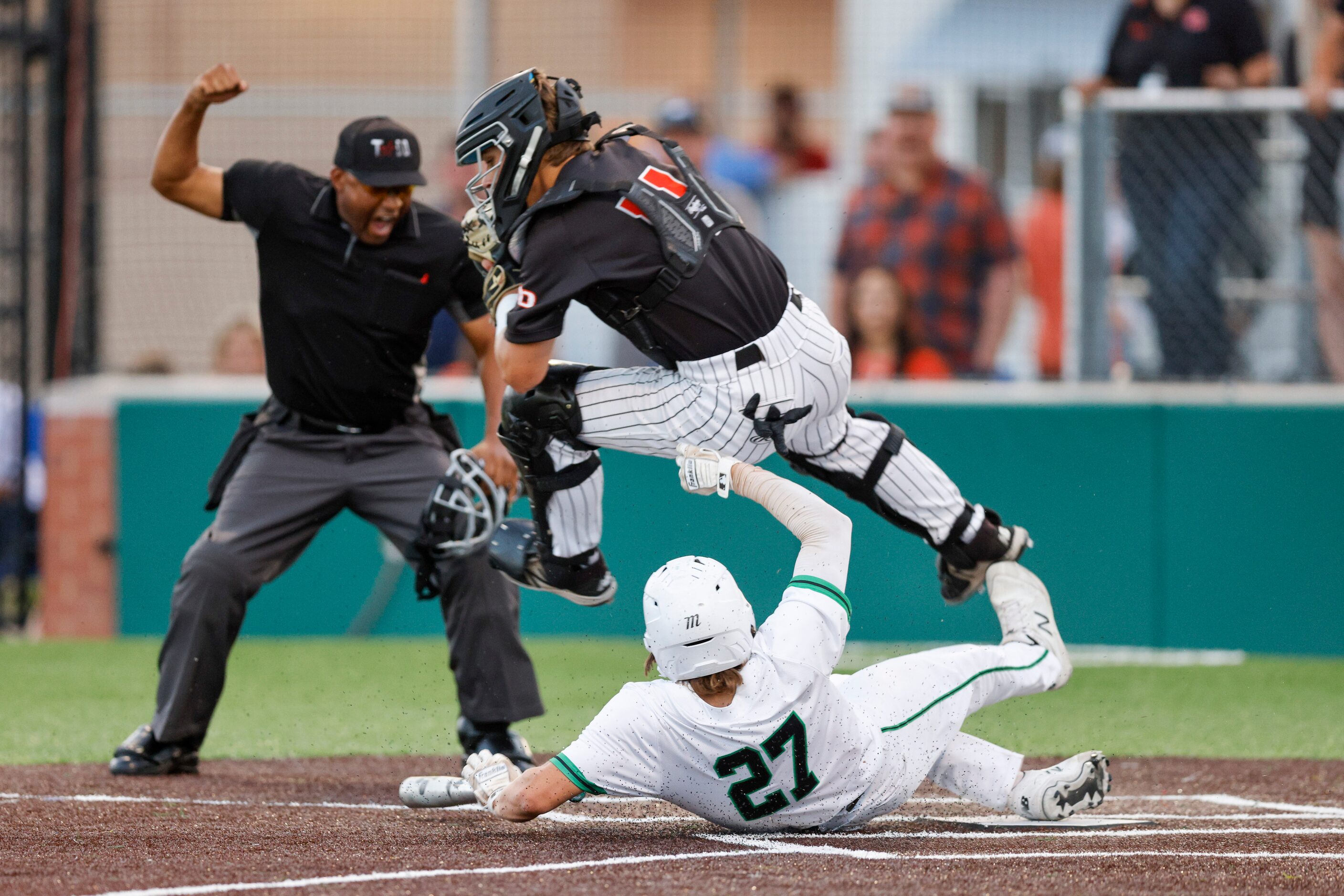 Waxahachie designated hitter Chase Pope (27) collides with Rockwall catcher Jake Overstreet...