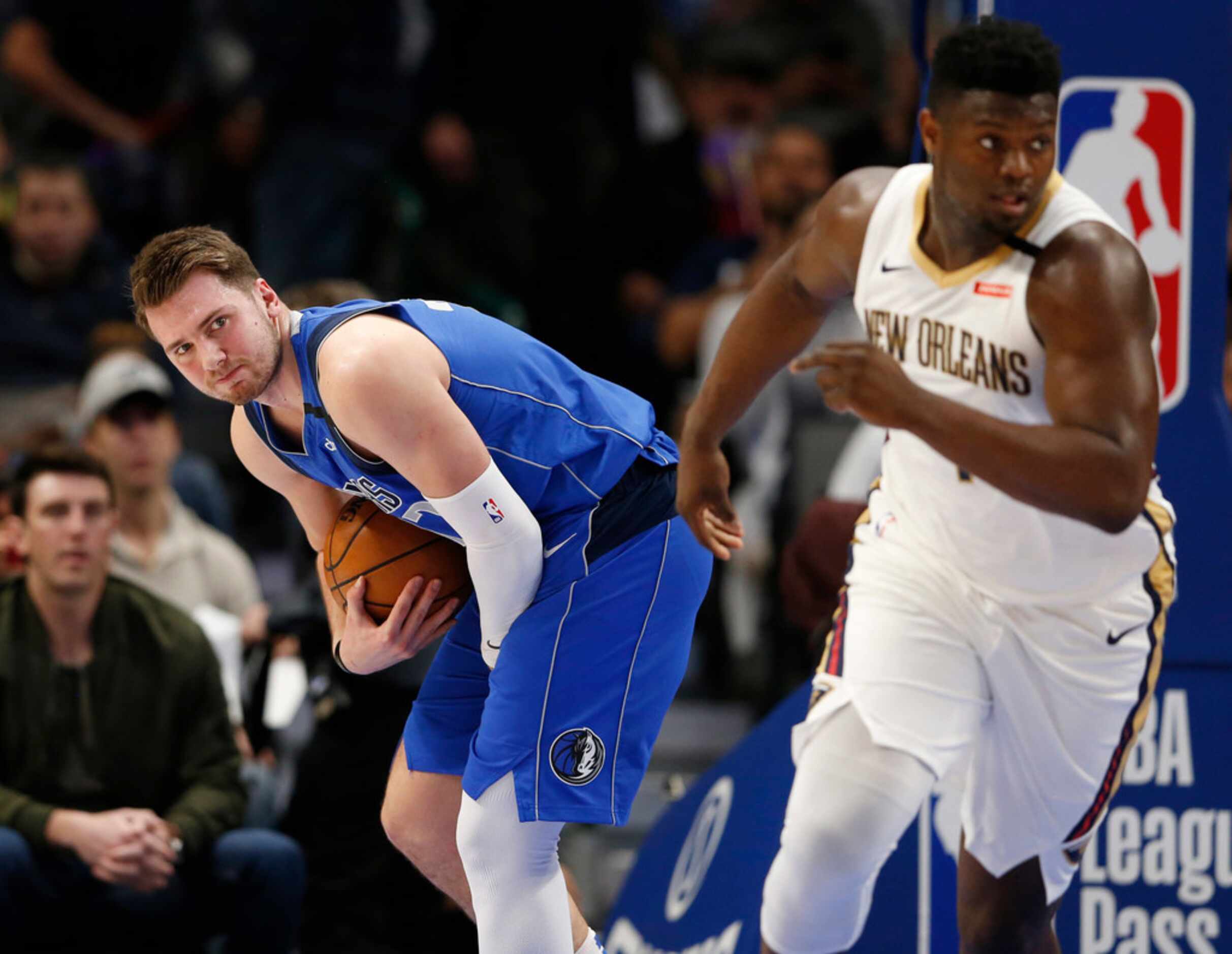 Dallas Mavericks guard Luka Doncic (77) grimaces after getting hit in the hand as he grabs a...