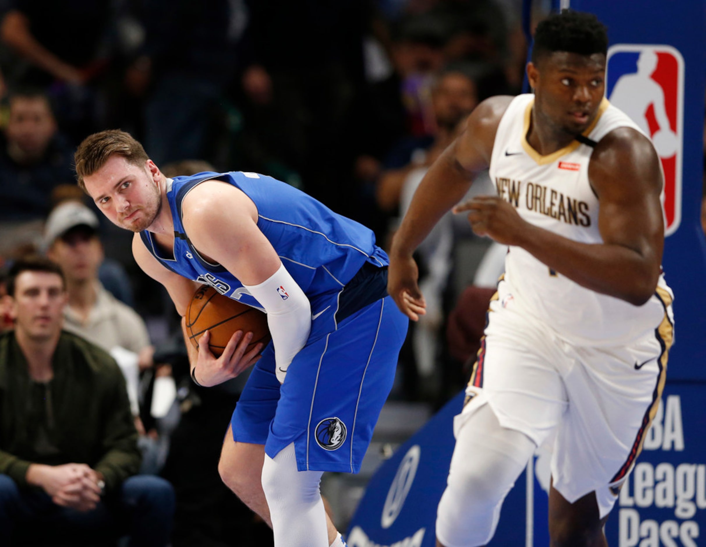 Dallas Mavericks guard Luka Doncic (77) grimaces after getting hit in the hand as he grabs a...