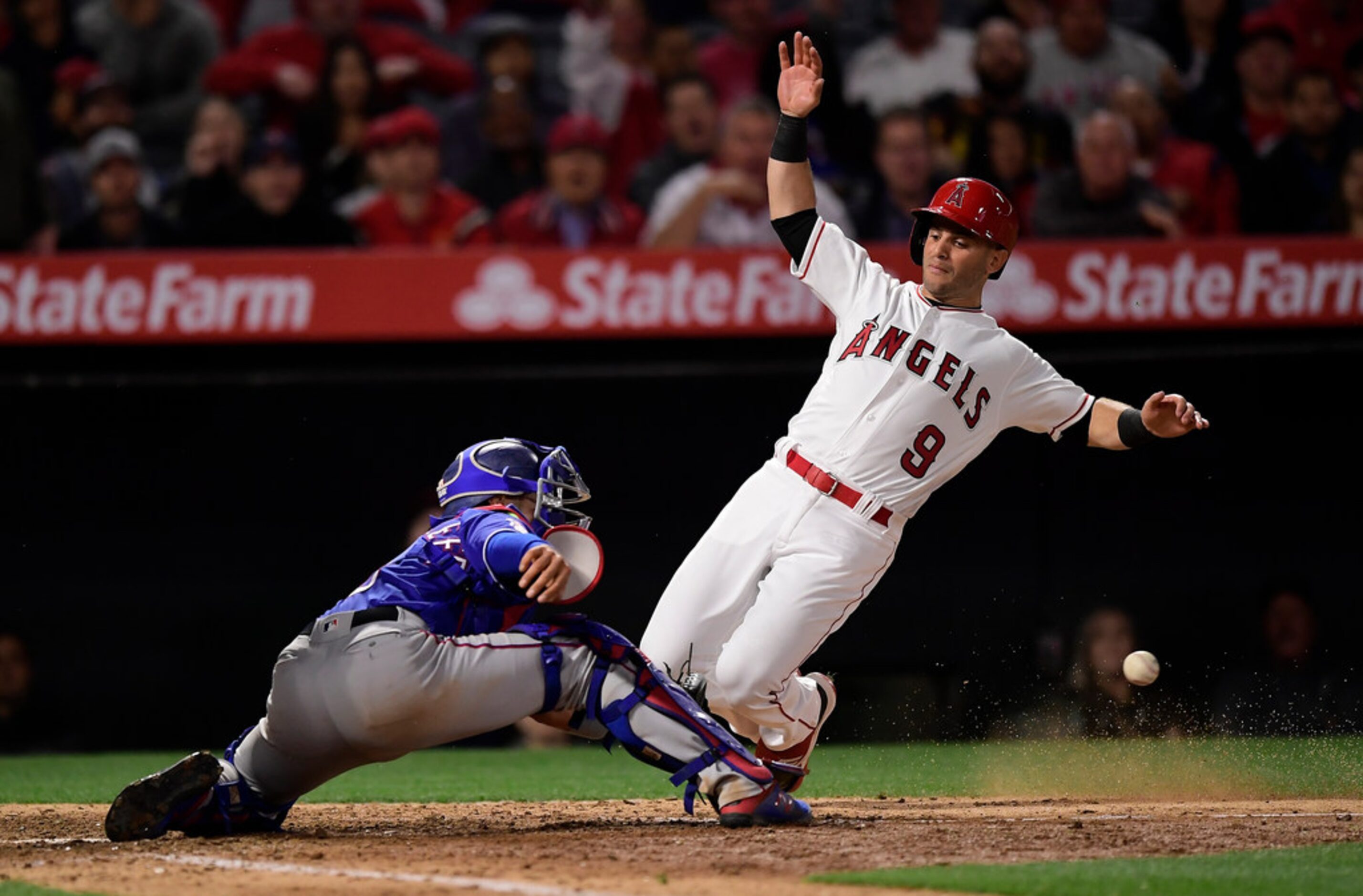 Los Angeles Angels' Tommy La Stella, right, scores on a double by Brian Goodwin as Texas...