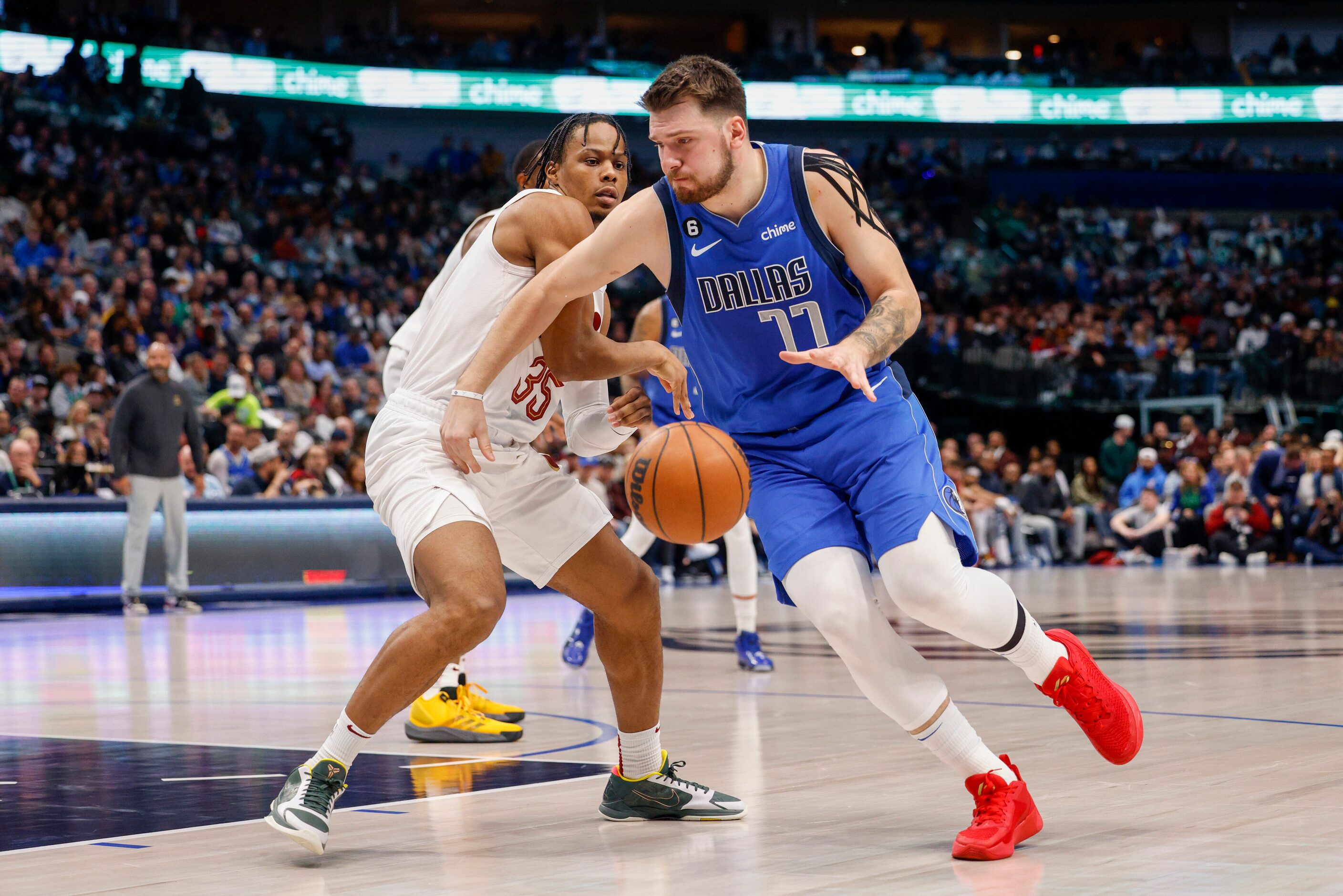 Dallas Mavericks guard Luka Doncic (77) dribbles around Cleveland Cavaliers forward Isaac...