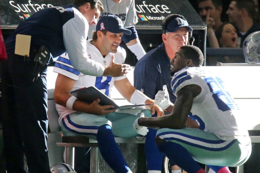 Dallas Cowboys quarterback Tony Romo (9) talks with  wide receiver Dez Bryant (88) on the...