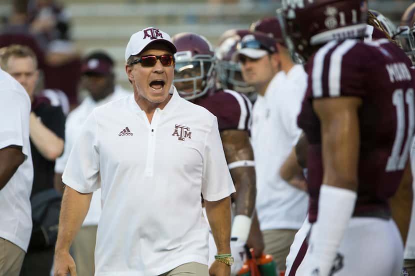 FILE - Texas A&M Aggies head coach Jimbo Fisher works with players during warmups prior to a...