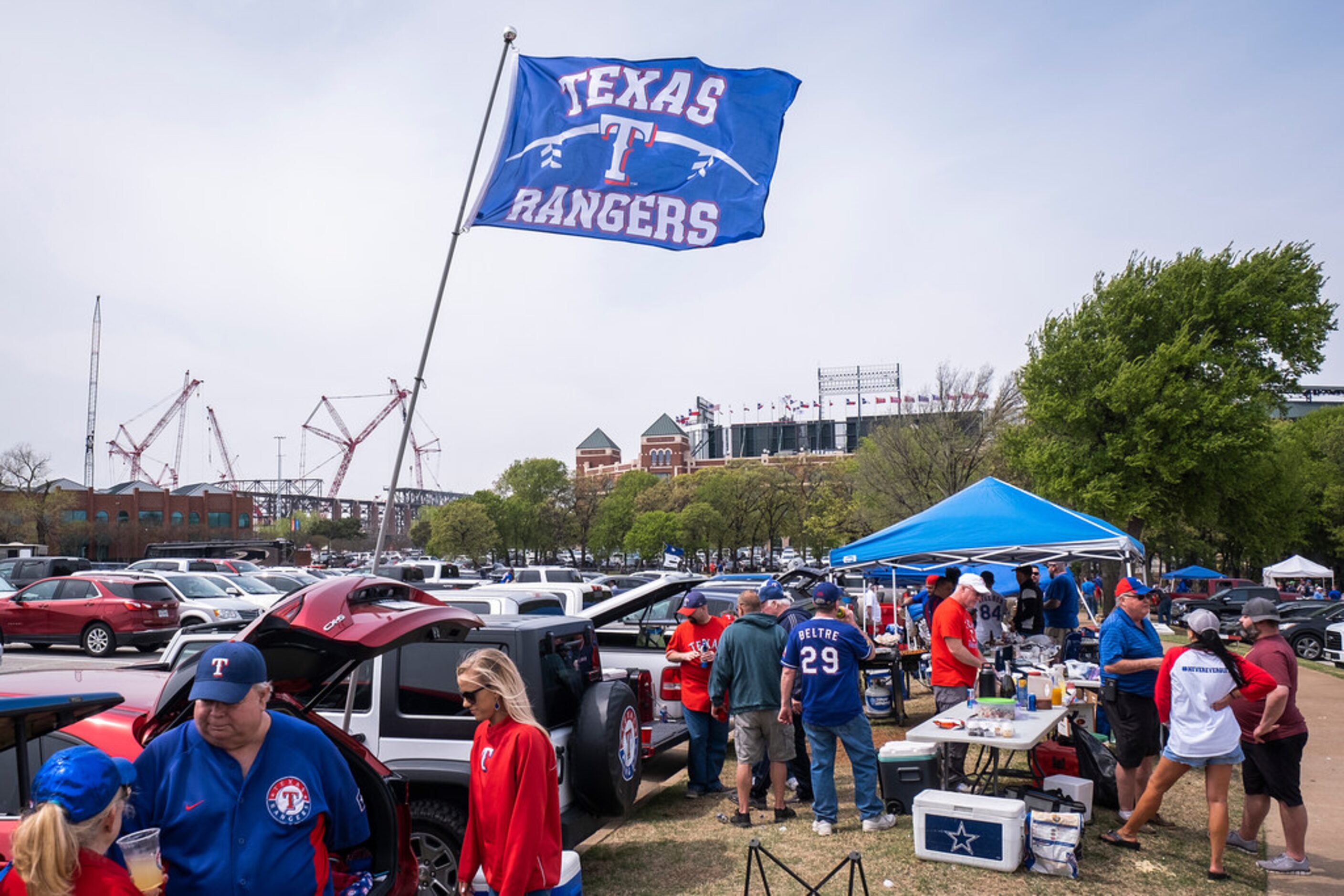 Globe Life Field rises to the left as Texas Rangers fans tailgate before the Texas Rangers...