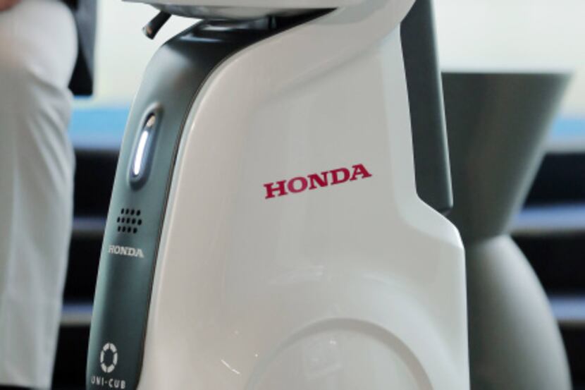 Swaying your body from side to side is what makes Uni-Cub go. Honda Motor Co.'s new robotics...