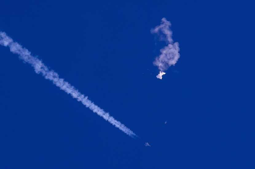 In this photo provided by Chad Fish, the remnants of a large balloon drift above the...