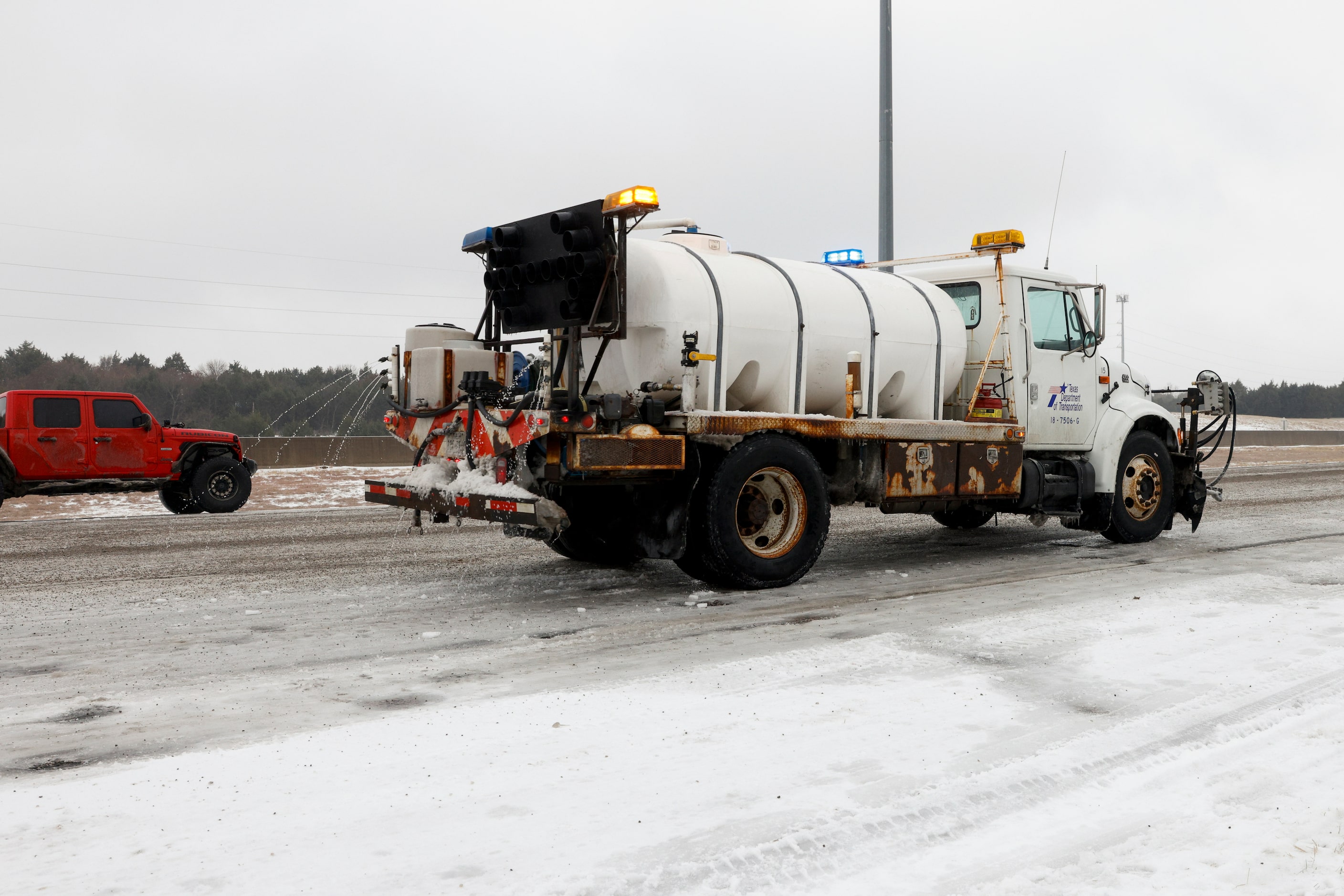 A TXDOT truck sprays an ice treatment on westbound I-20 after the Carnales Off Road Jeep...