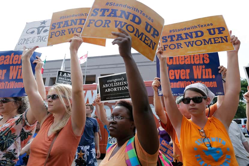 Opponents and supporters of an abortion bill hold signs near a news conference outside the...