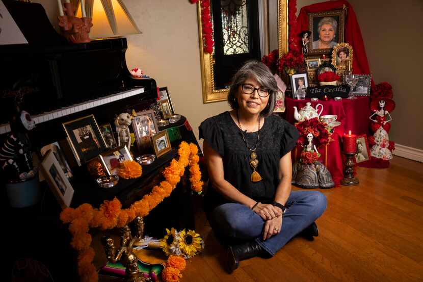 Debbie Flores Renteria poses next to ofrendas she has dedicated to her deceased loved ones...
