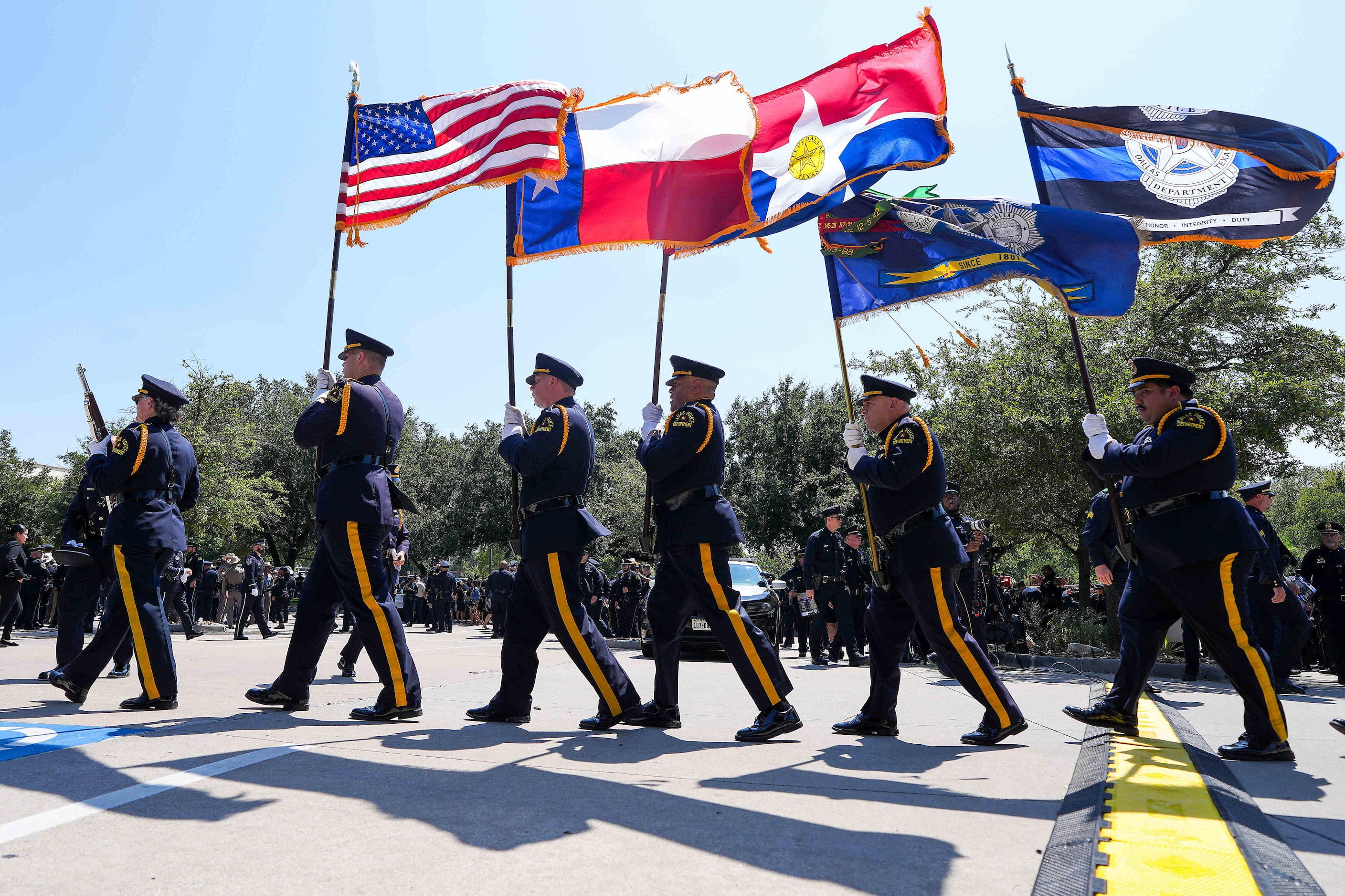 Members of the Dallas Police Honor Guard retire the colors following funeral services for...