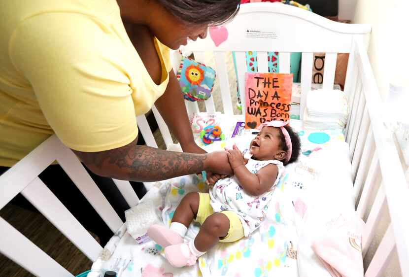 Na'Tiffany Thomas plays with her 4-month-old daughter, Natoria, in a former hotel room that...