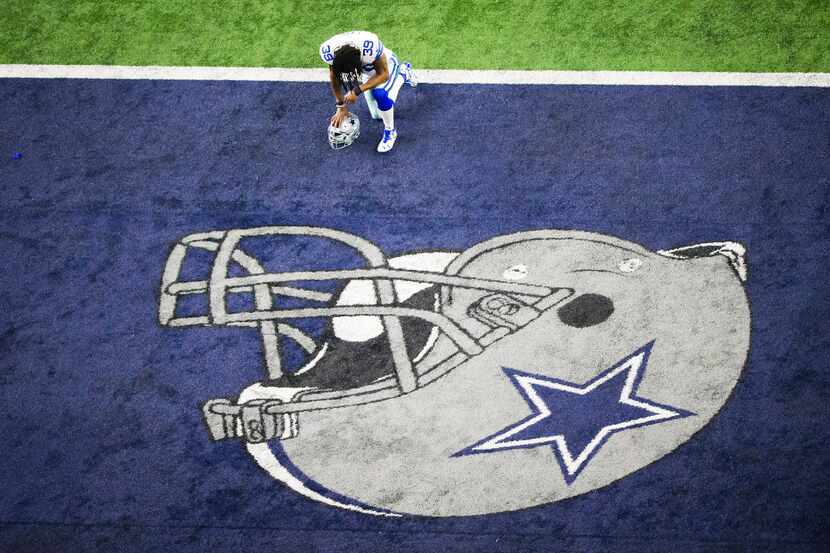 Dallas Cowboys cornerback Brandon Carr kneels in prayer before an NFC divisional round...
