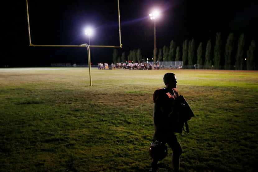  Tonopah player Alex Katzenback walks off the field following a high school football game...