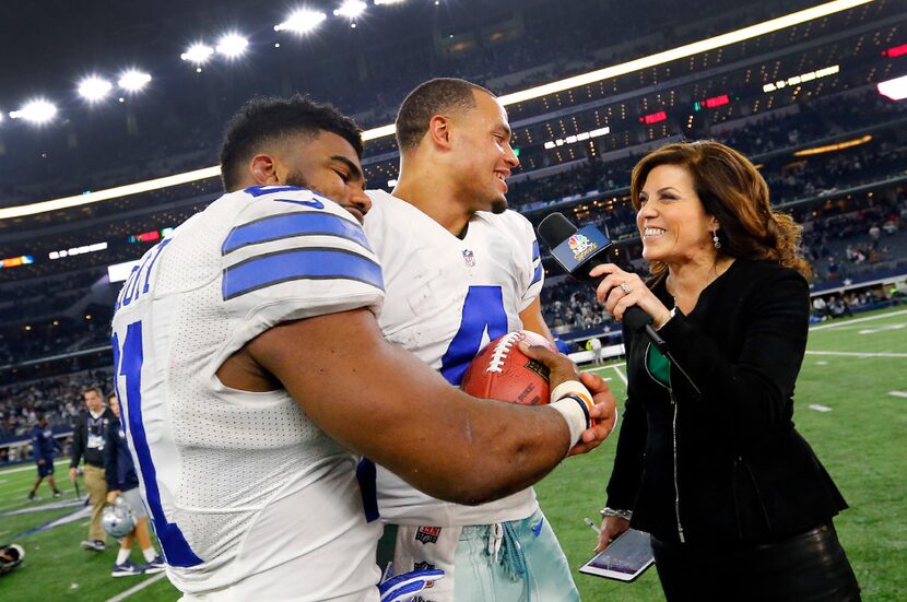 Dallas Cowboys running back Ezekiel Elliott (21) lays his head on quarterback Dak Prescott...