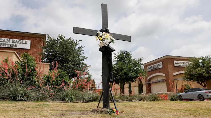A lone cross stands where a large memorial for victims of the Allen Premium Outlets shooting...