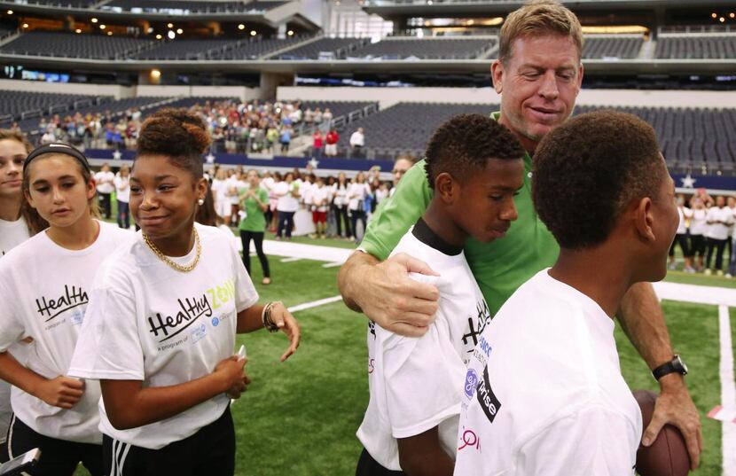 
Troy Aikman pals around with students from Arlington ISD's Young Junior High School at the...