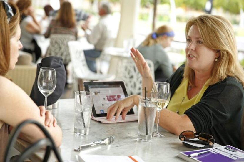 Ellen Coleman and Kelly Shield, both from Dallas, visit on the patio patio of Savor,...