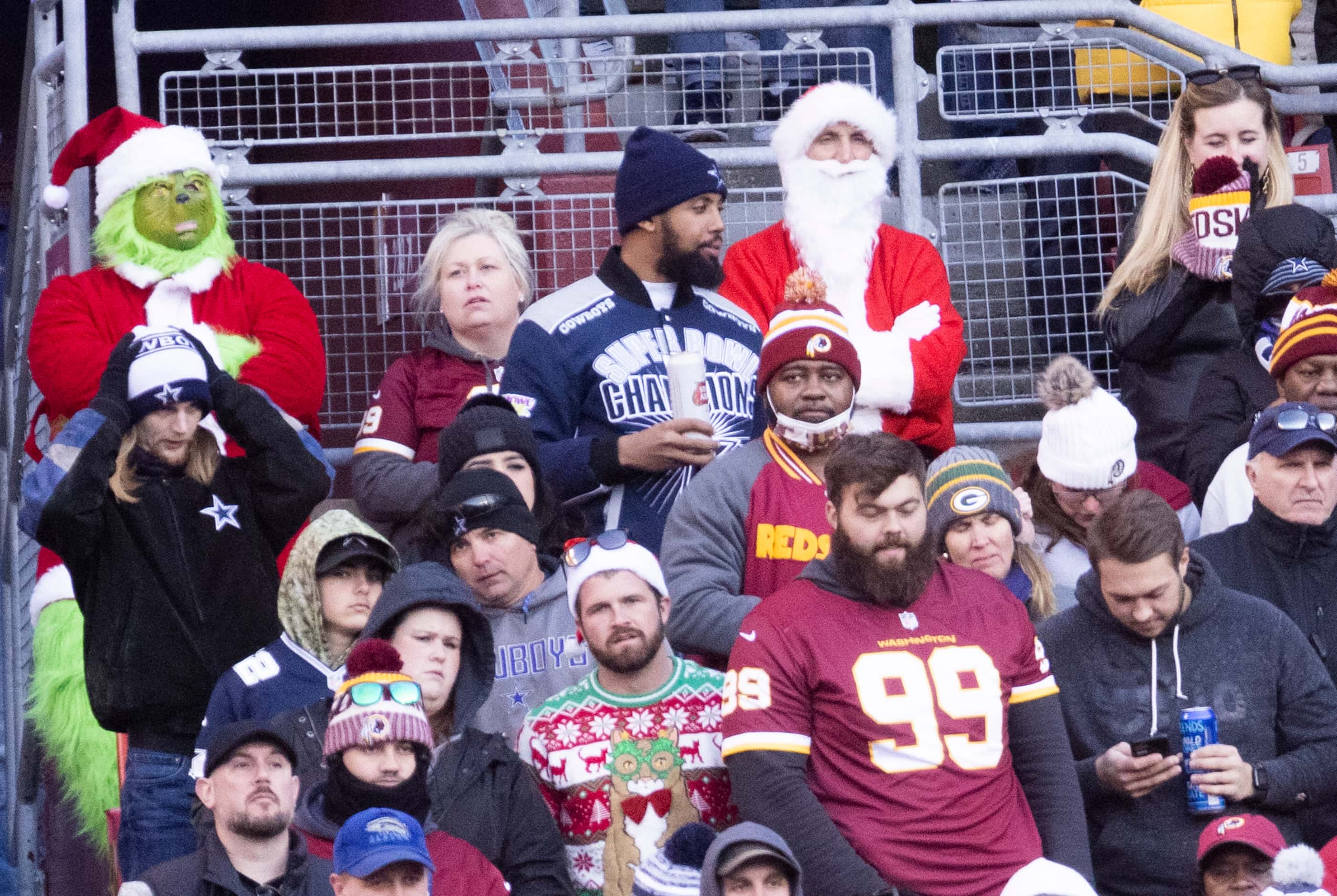 The Grinch and Santa watch during the third quarter of an NFL game between the Washington...
