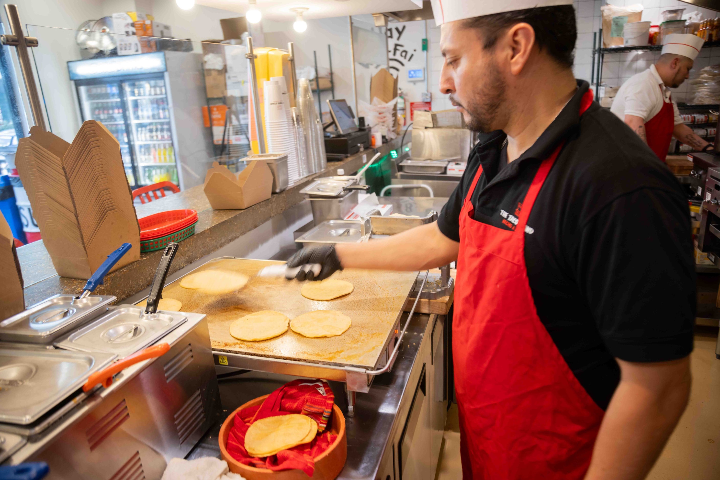 Enrique Peralta, regional manager of The Taco Stand, flips the tortillas at Taco Stand...