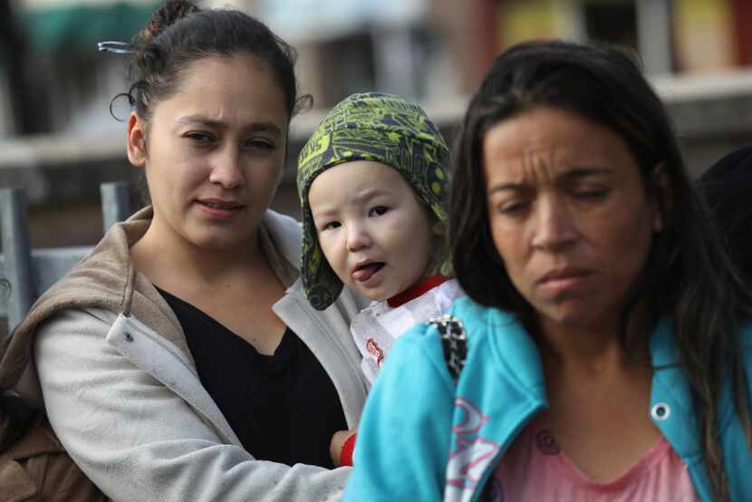 Immigrant families wait at a Catholic Charities sponsored "immigrant respite center" before...