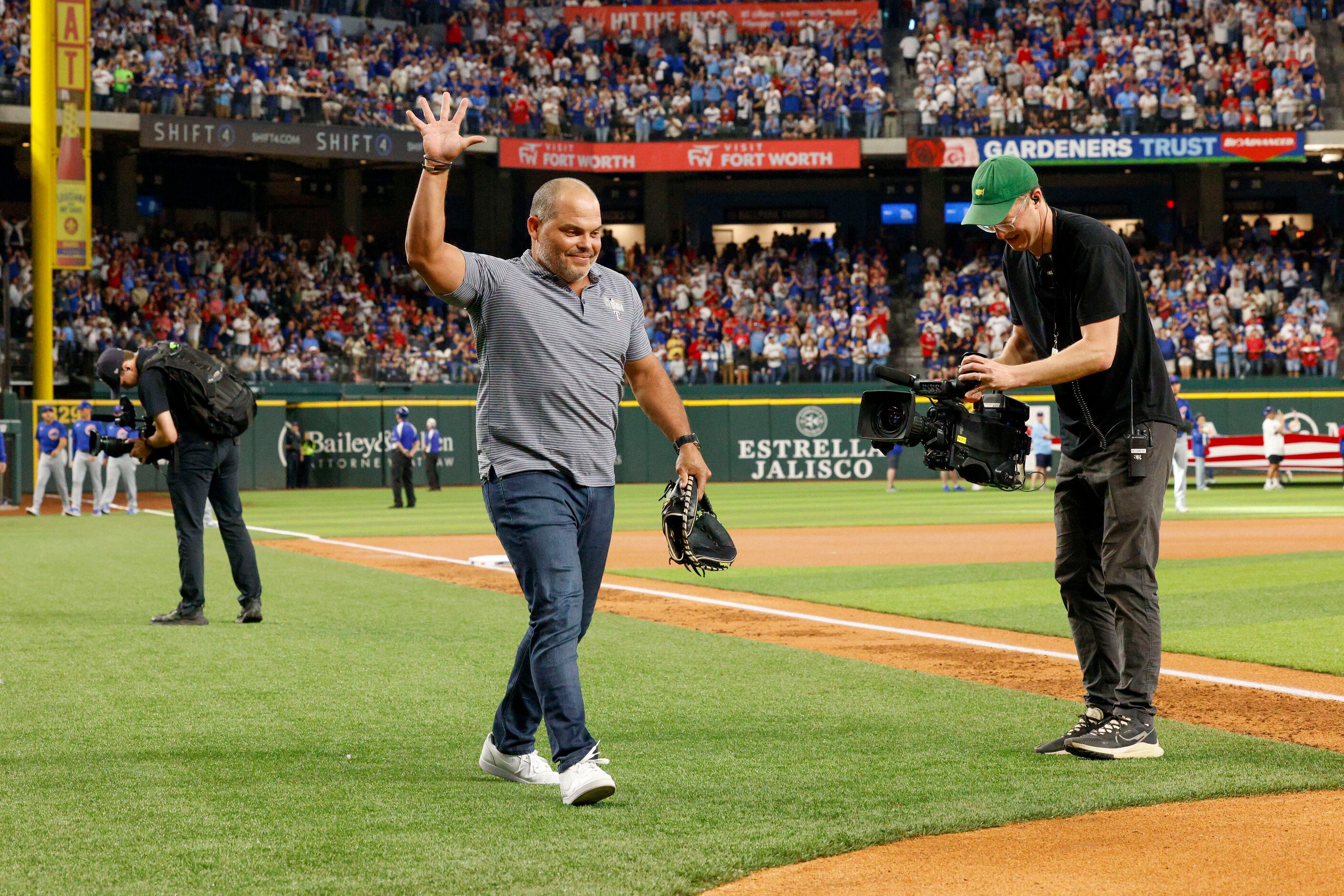 Texas Rangers Hall of Fame catcher Iván “Pudge” Rodríguez waves to the crowd as he walks out...