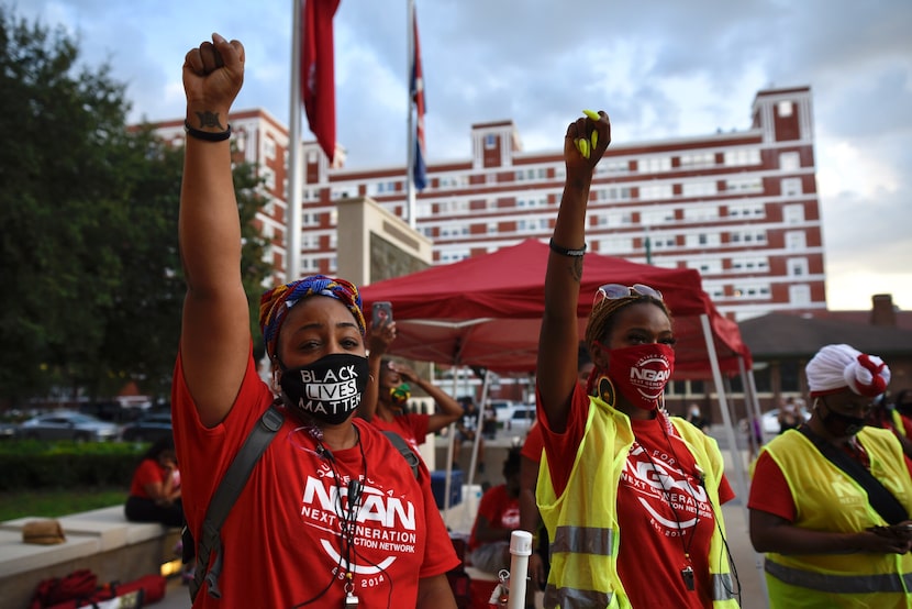 Ashley Washington, left, and Toi McIntosh, both of the Next Generation Action Network, raise...