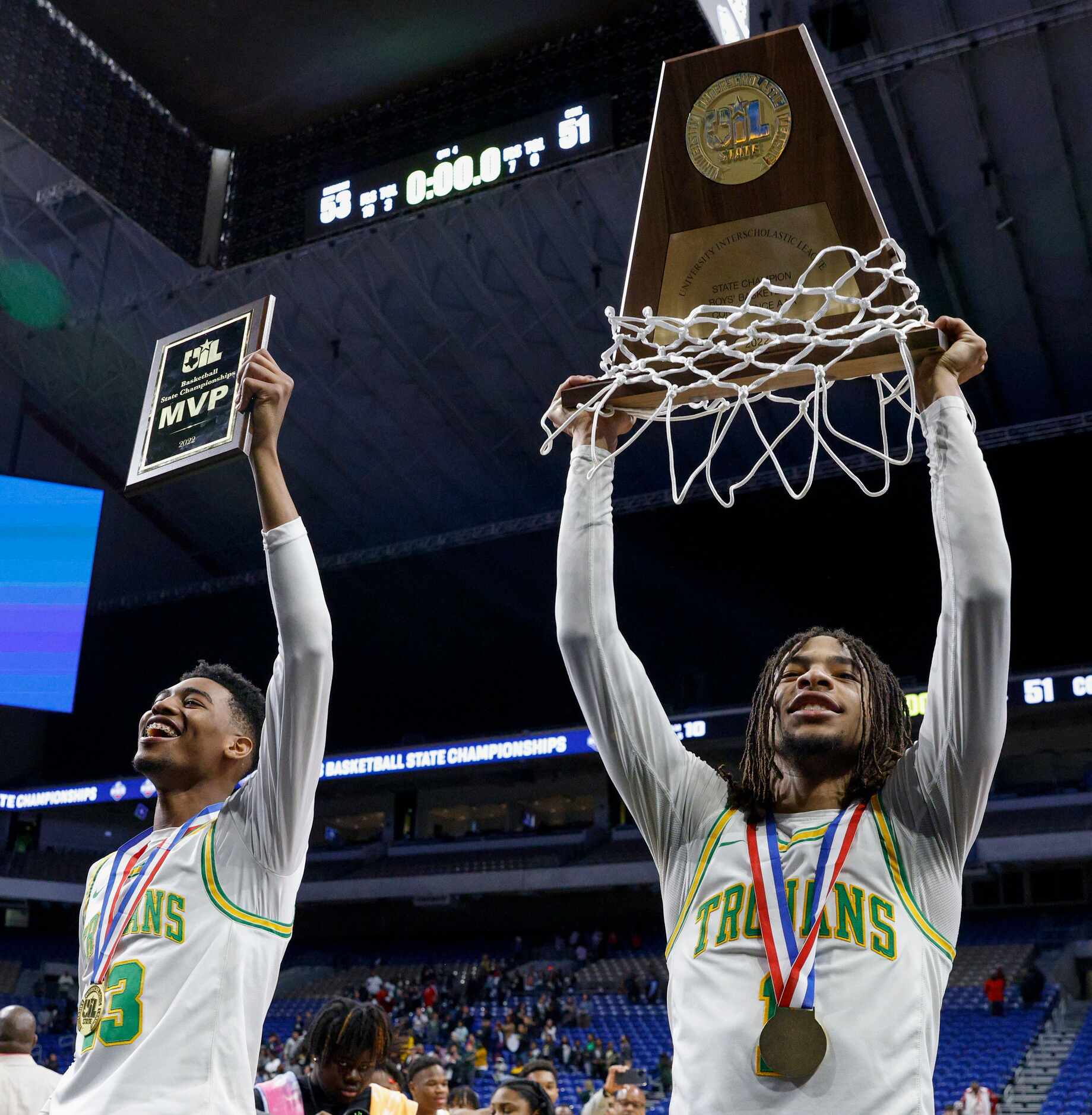 Madison forward Rodney Geter (13) raises the MVP trophy as Madison guard Pierre Hunter (1)...