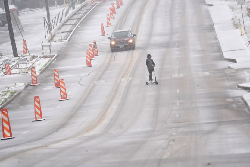 Una persona viaja en scooter en una calle de Dallas este 9 de enero.