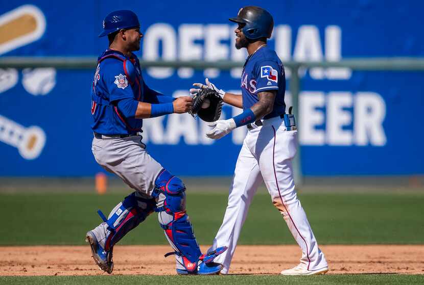 Rangers outfielder Delino DeShields waits with a smile and a hug to be tagged out by Chicago...