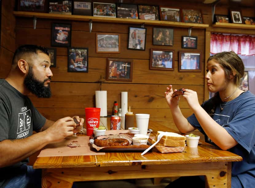 Pete and Dakota Rodriguez of Houston react after taking their first bite of a rib at Snow's...