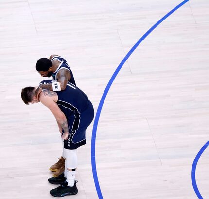 Dallas Mavericks guards Kyrie Irving (11) gives Luka Doncic (77) a hug late in the fourth...