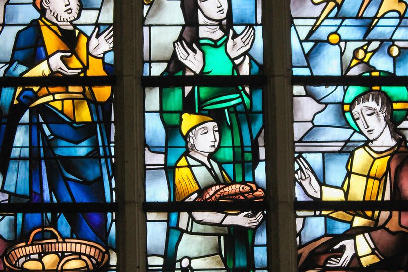 Stained glass in the Church of Tervuren, Belgium, depicts the Gospel account of feeding the...