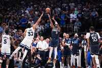 Dallas Mavericks guard Kyrie Irving (11) hits a 3-pointer over Minnesota Timberwolves center...