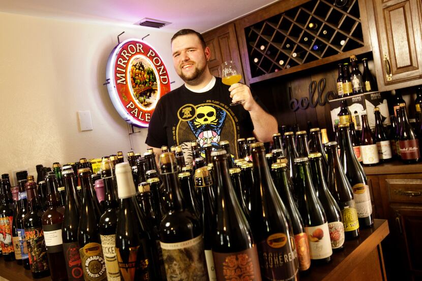 Jase Hicks poses with some of his specialty beers at his home in The Colony.