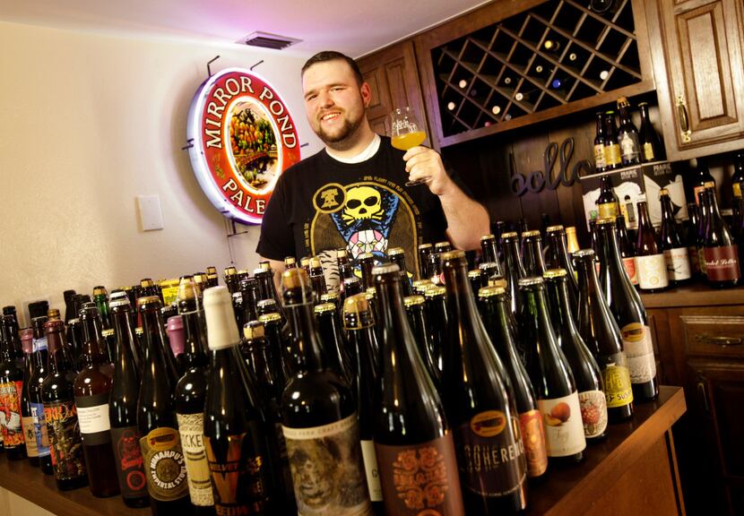 Jase Hicks poses with some of his specialty beers at his home in The Colony.