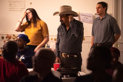 Julio Chaparro, center, co-chair of Justice For Joppa, adjusts a headphone as he listens to...